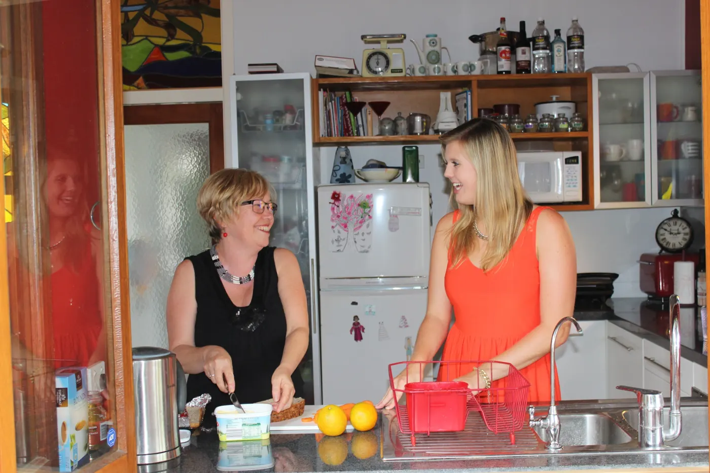 Una studentessa e la madre della famiglia ospitante chiacchierano in cucina