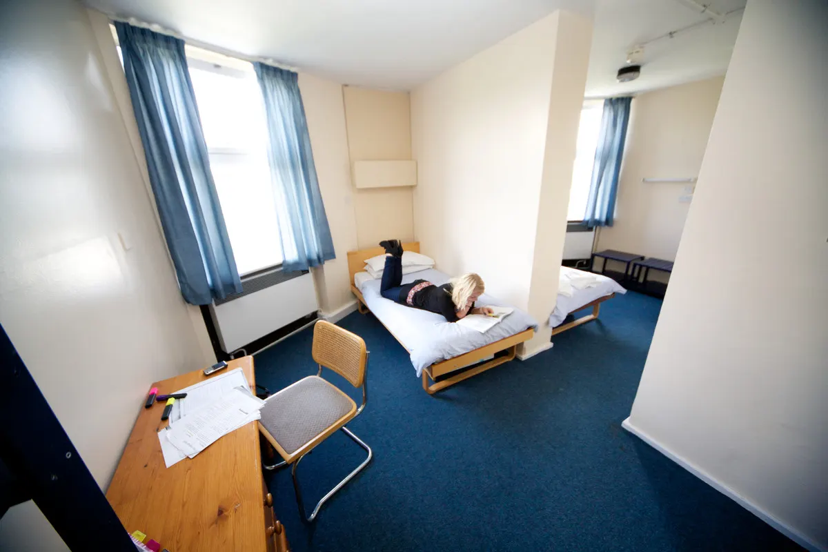 Uno studente riposa sul letto nella sua camera in residenza